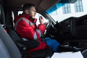 Male ambulance driver using a radio